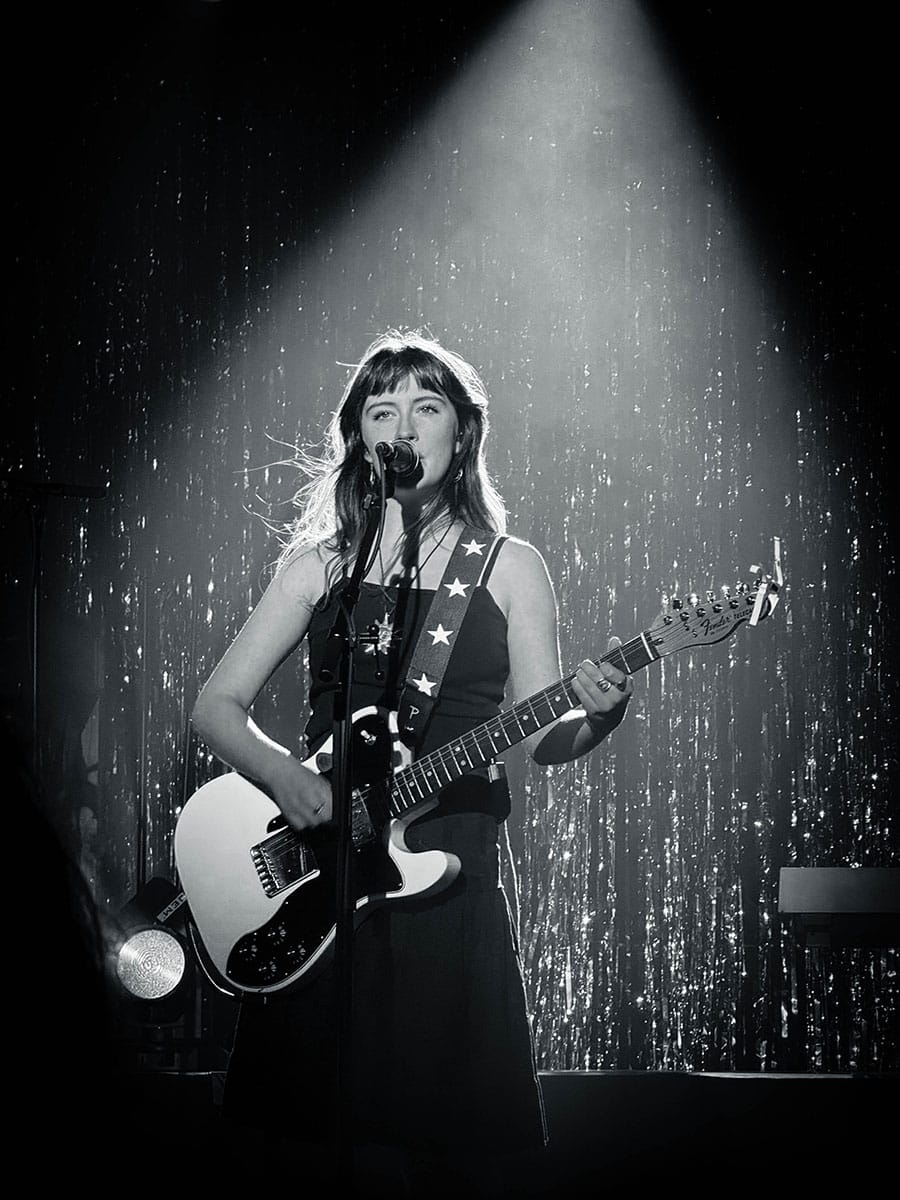 This picture shows a black and white concert photo of the lead singer of the band Florence Road, taken by Sara Vukman.