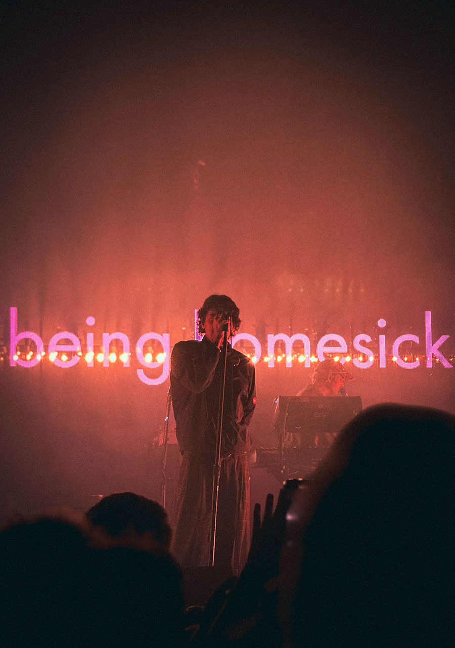 The picture shows a concert photo of the lead singer of the band Royel Otis, taken by Sara Vukman. The photo captures the intensity and emotion of the performance, highlighting the lead singer as the central figure on stage while the background is blurred, emphasizing the focus on the artist.