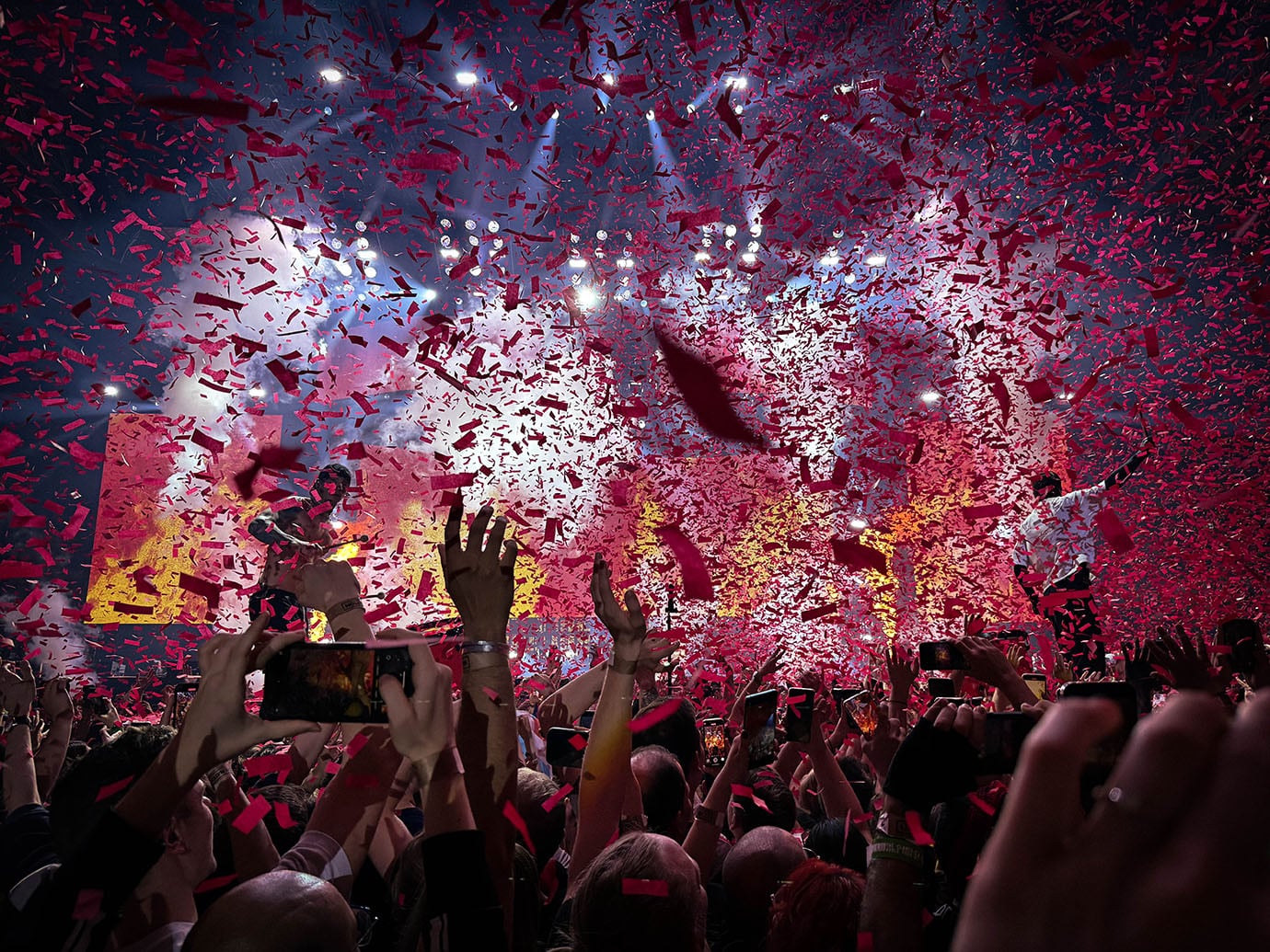 The picture shows a second concert photo of the band Twenty One Pilots, taken by Sara Vukman. This photo is light and airy, capturing the band members in a moment of performance. The image emphasizes the connection between the artists and their audience, showcasing the excitement and engagement of the live music experience.